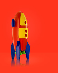 Child's Toy Rocket isolated on red background with reflection  