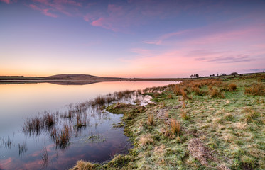 Obraz premium Beautiful sunrise over Dozmary Pool a mysterious lake steeped in Arthurian legend near Bolventor on Bodmin Moor in Cornwall
