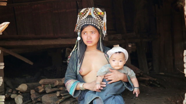 indigenous tribal native Akha woman carry baby in hill village