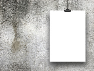 Close-up of one hanged paper sheet frame with clip on stained wall background