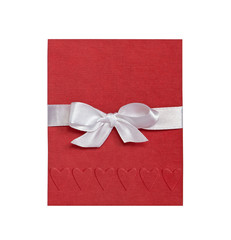 red card with embossed hearts and white bow on white background