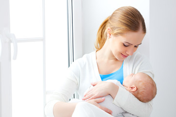 Obraz na płótnie Canvas newborn baby in tender embrace of mother