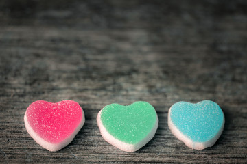 Obraz premium Colorful candy sweet hearts on wooden background.- Vintage filte