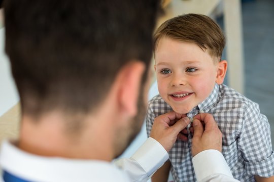 Father buttoning up son