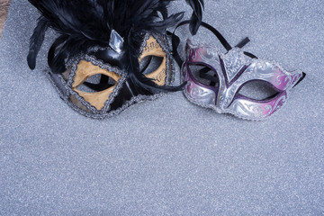 two carnival masks with feathers   on glitter