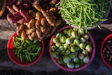 Baskets full of frsh vegetables under morning light at the street market, Vietnam.