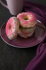 Pink homemade donuts on purple background