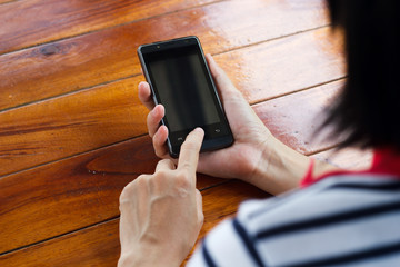 Hands touching smartphone bright background, closeup