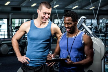 Muscular man discussing performance with trainer 