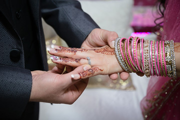 groom putting ring on