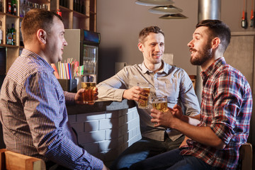 Fototapeta na wymiar Happy friends drinking beer at counter in pub