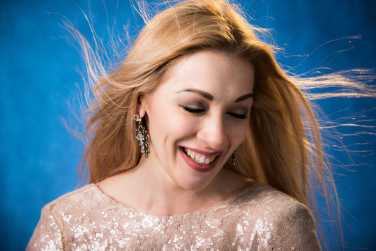 Радостная девушка с развивающимися волосами на синем фоне