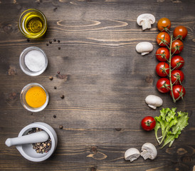 ingredients for the salad, oil, cherry tomatoes, lettuce, spices on wooden rustic background top view close up place for text,frame