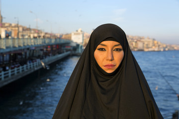 Woman dressed with black headscarf, chador on istanbul street, turkey