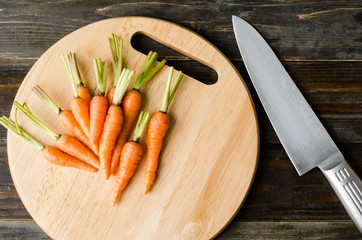 Fresh carrots on wooden plate ready for cooking