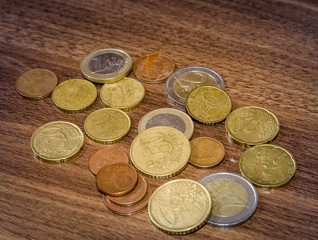 different euro coins on wooden table