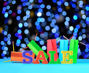 Sale written by colorful letters on the background of shopping b