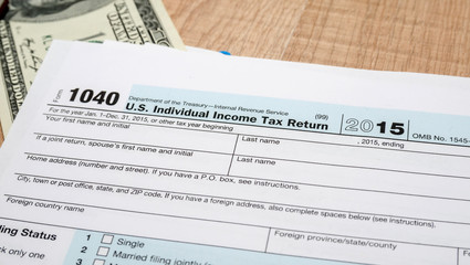 federal income tax return 1040 documents for 2016 year with calculator and dollars