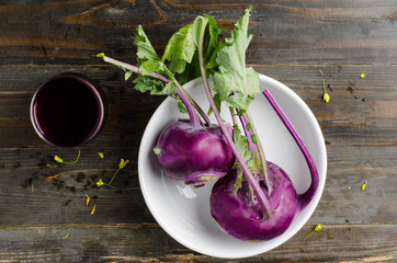 Purple kohlrabi in the bowl on wooden background