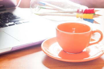 Coffee cup with keyboard on wooden table