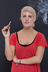 Obraz premium Stylish blond woman smoking an e-cigarette