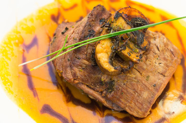 Delicious sirloin steak placed upon a bed of curry sauce on white dinner plate, elegant presentation