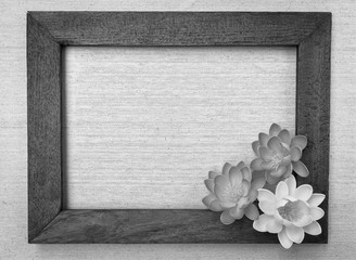 Black and white wooden picture frame with flower on canvas background