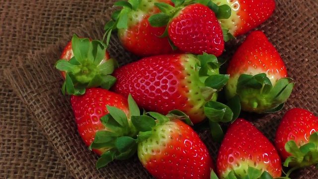 Pile of red strawberries on jute 
