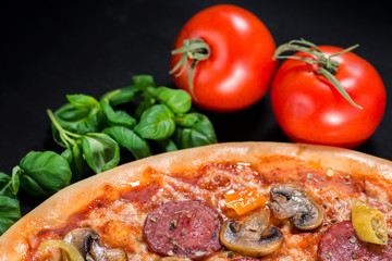 closeup Tasty pizza with tomatoes, mushroom, sausage, basil and