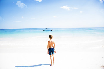 barca al largo di una spiaggia caraibica con mare dai colori turchesi 