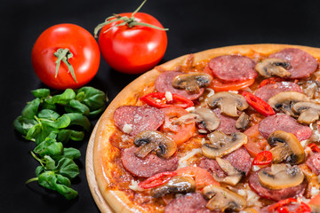 closeup Tasty pizza with tomatoes, mushroom, sausage, basil and