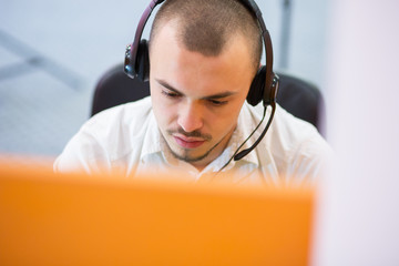 businessman with a headset portrait at bright call center helpde