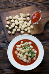 Above view of italian potato gnocchi served with tomato sauce
