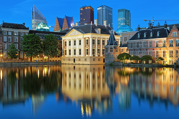 Fototapeta na wymiar The Hague, Netherlands. The Mauritshuis on the shore of Hofvijver Pond (Court Pond) on the background of the city's skyscrapers in the evening.