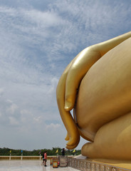 People and part of huge gold buddha statue in Thailand