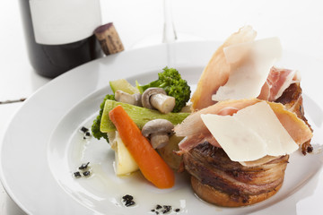 Roasted beef fillet on plate with wine glass and bottle