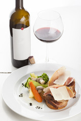Roasted beef fillet on plate with wine glass and bottle