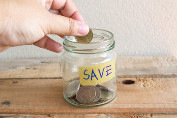Money Saving concept , hand putting money coin inthe mug