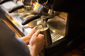 close up of woman making coffee by machine at cafe