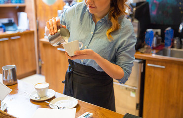 close up of woman making coffee at shop or cafe