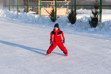 Happy child skating in winter at the rink