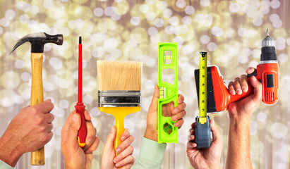 Hands of handyman with tools.