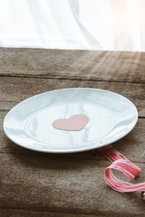 Valentines day table setting with plate,  red ribbon and hearts
