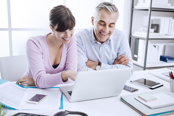 Office workers networking with a laptop