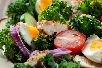 Fresh salad with chicken, tomatoes, eggs and lettuce on plate