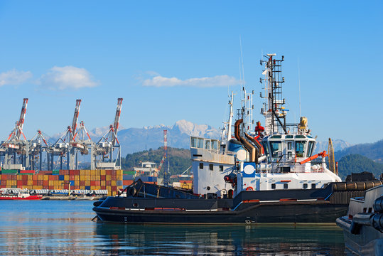 Harbor of La Spezia - Liguria Italy / Tugboats, containers and cranes in the harbor of La Spezia, Liguria, Italy. In the background the Apuan Alps