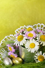 Bouquet of daisies in a metal bucket and shocolate eggs