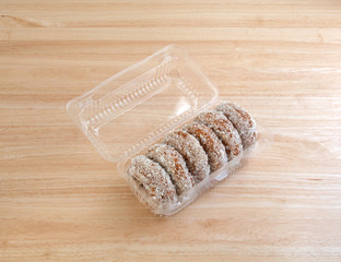 Plain coconut flake donuts in an open container