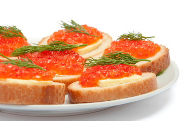 Bread with butter and red caviar in white plate. Sandwiches with