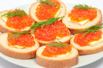 Bread with butter and red caviar in white plate. Sandwiches with